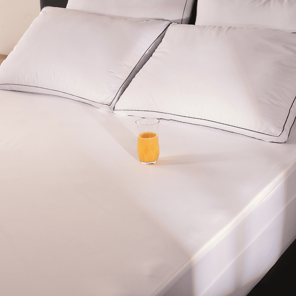 Protetor de colchão impermeável Ortobom — copo de suco sobre o protetor